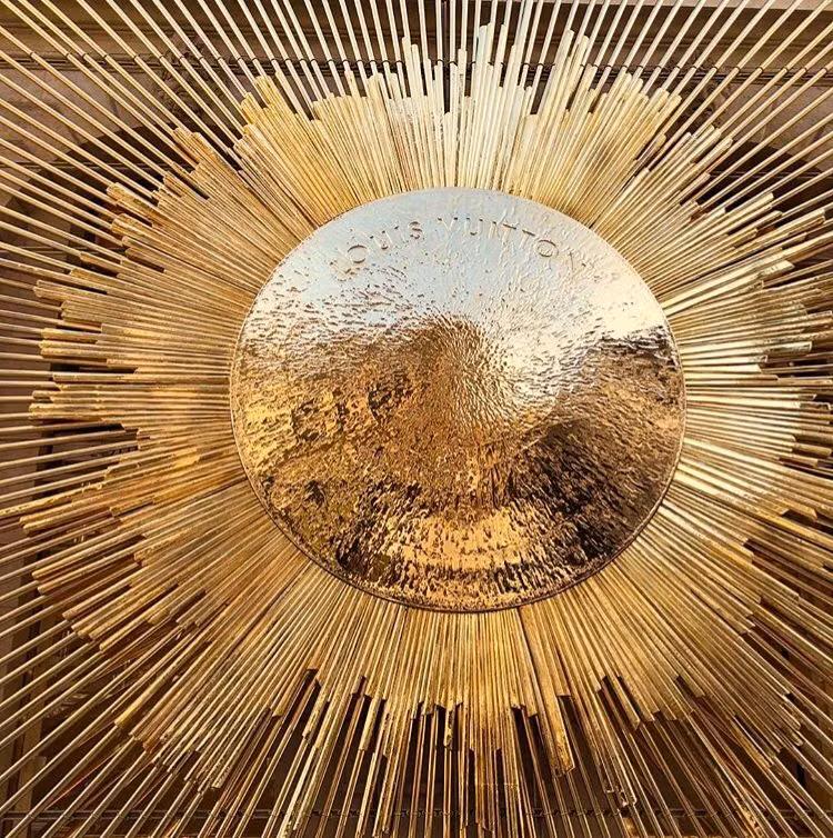 brass sunburst object close up photograph -