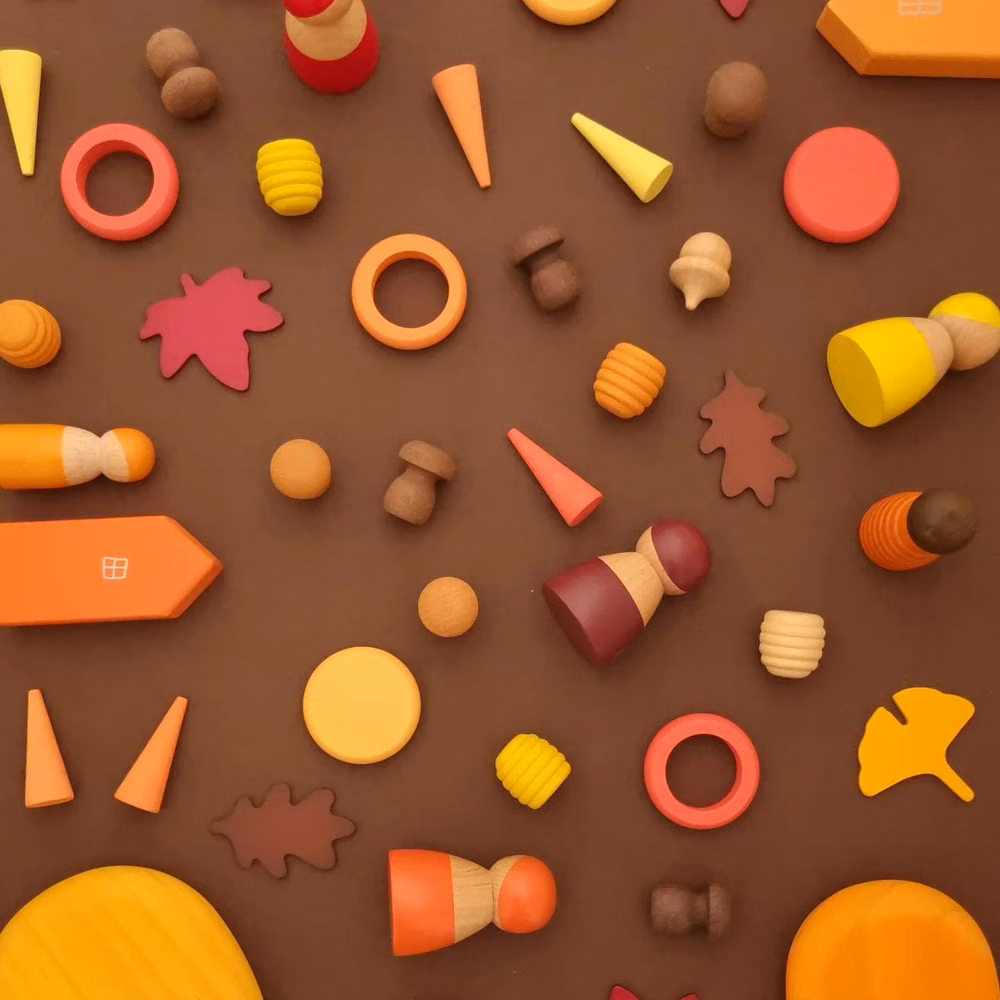 primary color wooden toys overhead photograph - Halloween has passed and I am anticipating the incoming festive themed posts, but for now we are still enjoying the seasonal changes, which have been slow around us. Here is a flat lay of autumnal coloured toys we are enjoying playing with at the moment. Shop the loose parts, pebbles and peg dolls on our website www.fourkidstoys.com Rings and discs set back in stock next month