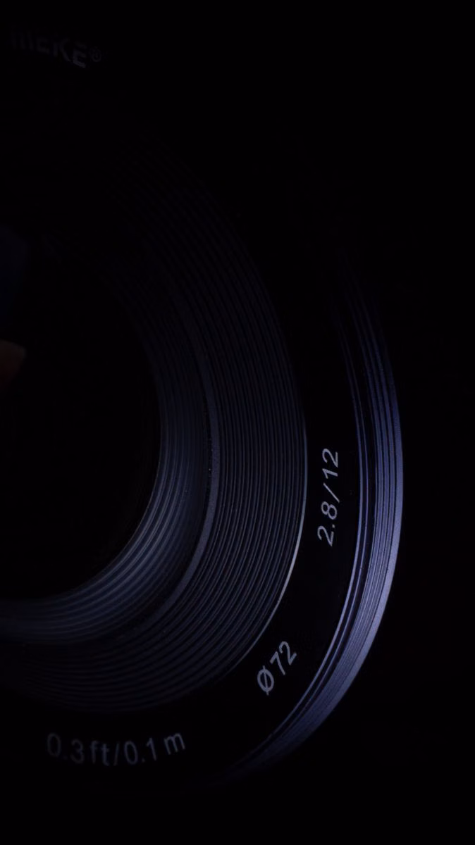 precision optical lens black background photograph - 