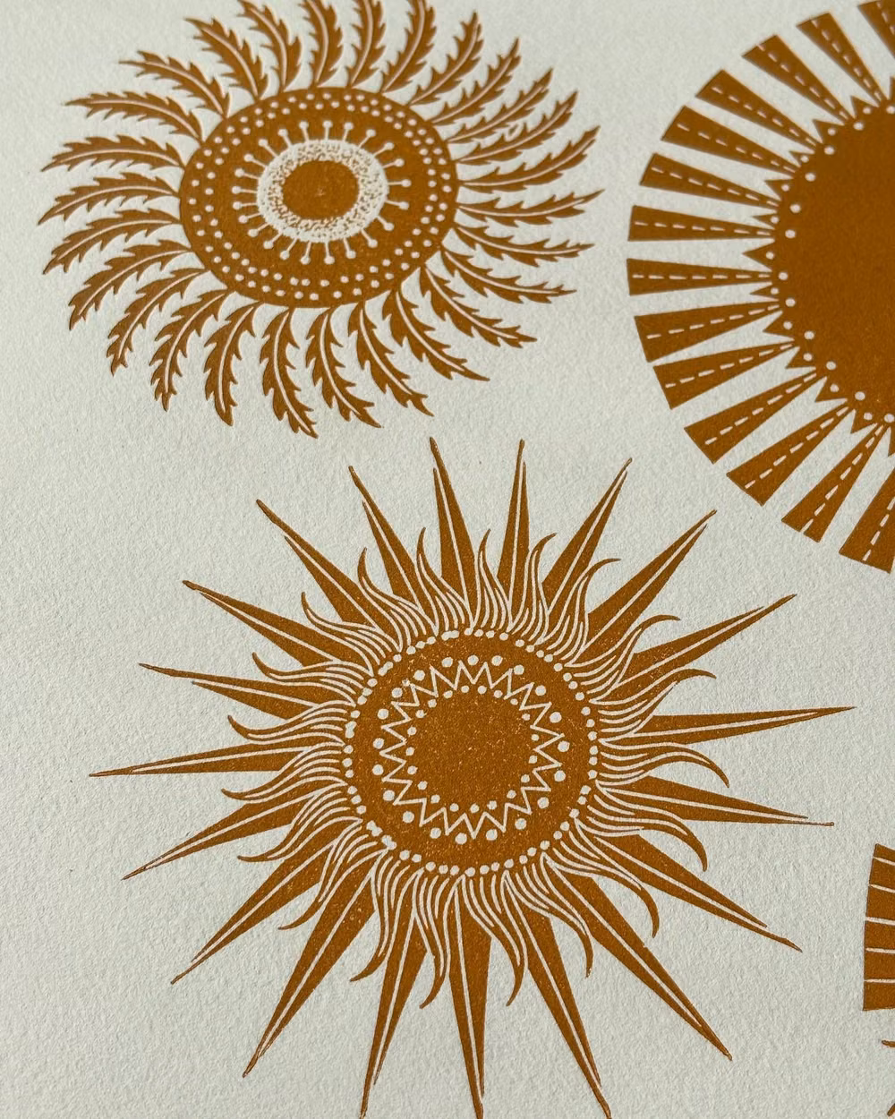 hand carved woodcut sun print photograph - I’ve carved a bit more from the first comet blocks so now they look like mini suns. Bright sunlight this morning on my desk too, and I’ve been watching the blue tits checking out the bird box. Last year I had a nest but sadly the box fell off the wall, so I’ve made sure it’s securely attached this year. #comets #spring #printmaking #linoprint #popmembers