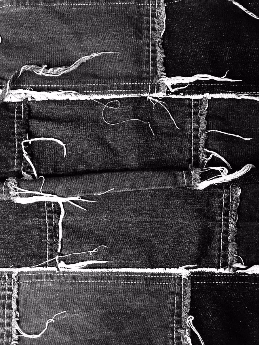 distressed black denim fabric macro photograph -