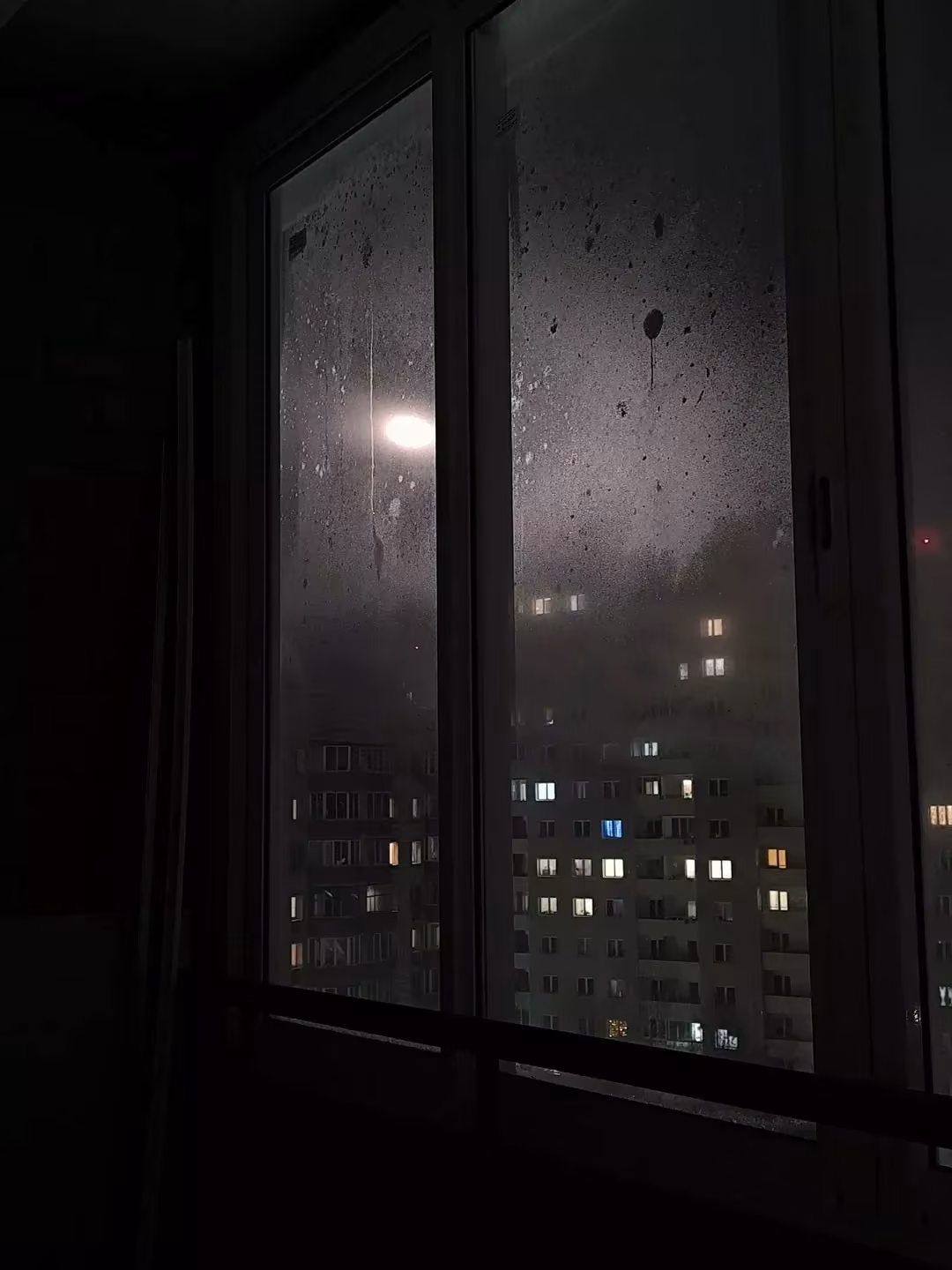 rainy apartment window city night photograph -