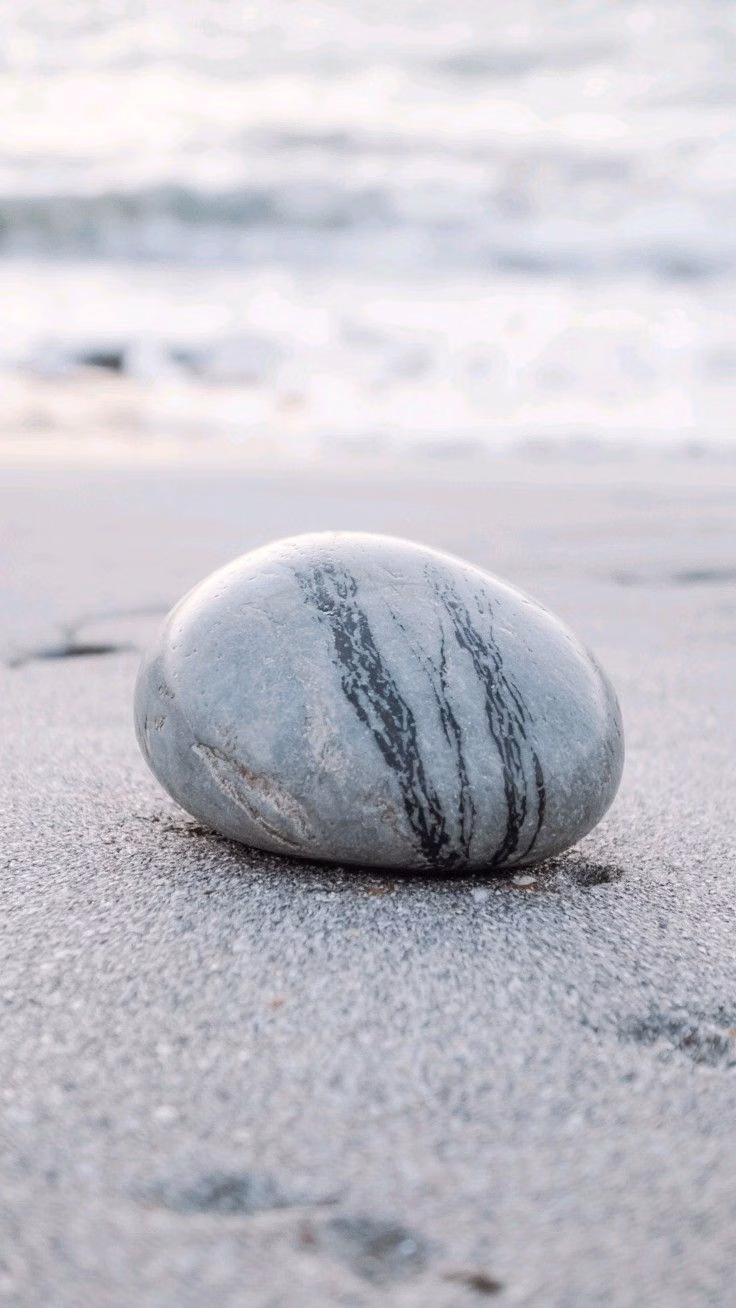 single stone on sand minimal photograph -
