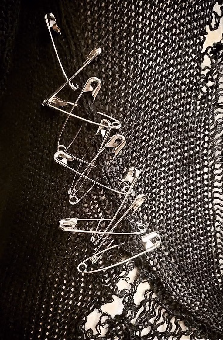 safety pins black fabric close up photograph -