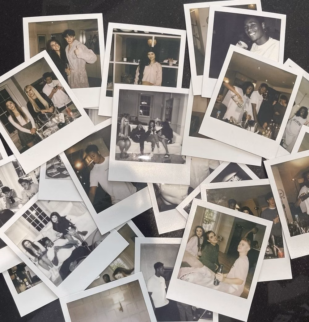 instant film photographs scattered overhead -