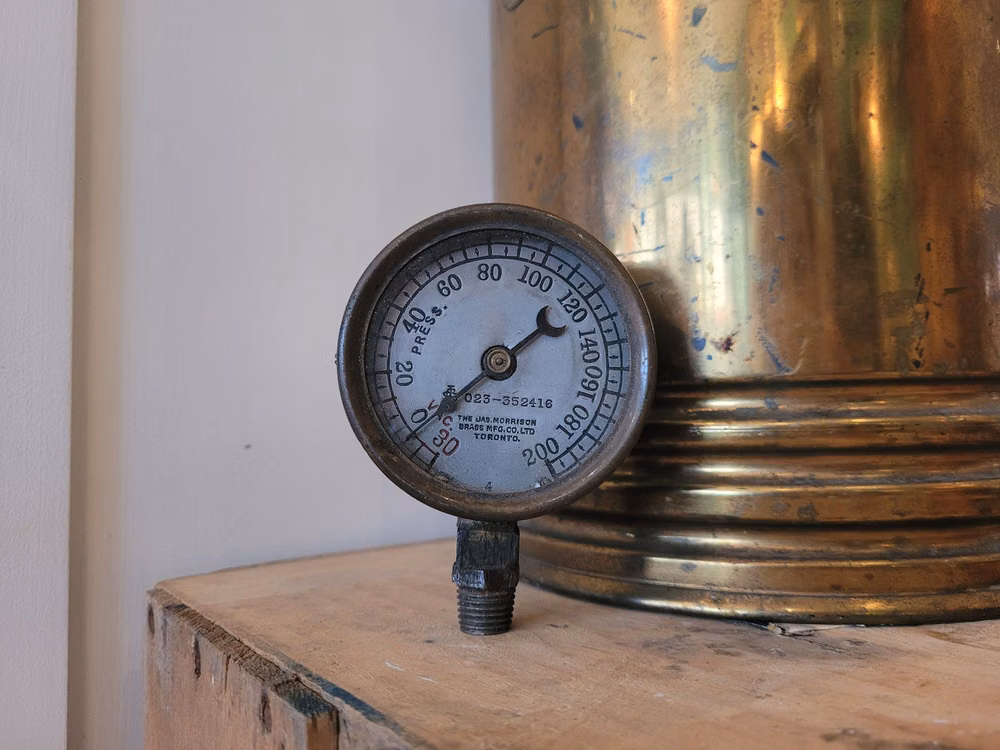 antique steam pressure gauge close up photograph - This is a beautifully made antique pressure gauge made by The James Morrison Brass Mfg Co. in Toronto, Canada. It is in used condition, but looks amazing for being 100ish years old. It features a brass ring around the glass covering, which has no scratches or cracks. The face in side is well crafted with all the numbers and info stamped into the metal and has a cool needle with a crescent moon. It does feature signs of age and use on the outside and back, see pics. It measures 2 3/4" in diameter and is 1 1/2" deep. The James Morrison Brass Mfg Co. was founded in Toronto in 1864. The business prospered and relocated in 1972 to a larger premises on Adelaide Street West. In addition to brass foundling and finishing, the company did business in engineers, steamfitters, plumbers and gas fitters