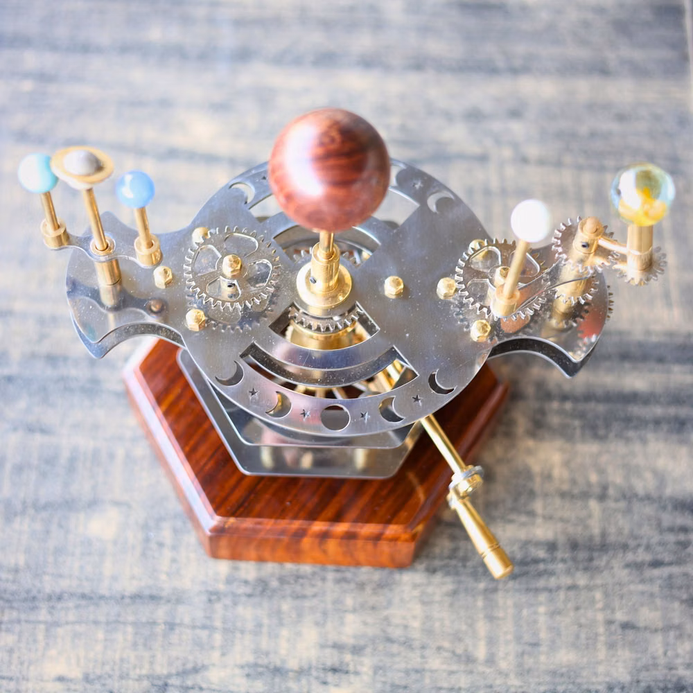 antique brass orrery mechanism photograph - Our Orrery is a fusion of Luxury artistry in Vintage Decor, engineering, and a deep admiration for the cosmos. Crafted with the utmost care, this functional orrery is not just a desk accessory; it's a masterpiece that captures the awe-inspiring beauty of our solar system while adding a touch of celestial Bodies to your Interior Décor. Marked as a Best Gift for House Warming. We are Actively Selling in USA and Worldwide -- Functional Art Meets Engineering In this Orrery lies an intricate web of gears, meticulously calibrated to mirror the graceful orbits of our planets. Watch in fascination as the planets gracefully circle the sun, just as they do in the vast reaches of the universe. This mesmerizing mechanical marvel is a testament to the art of engineering and a tribute to the wonders of